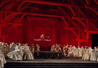 A man jumps into the air, surrounded by women wearing Queen Elizabeth I dresses