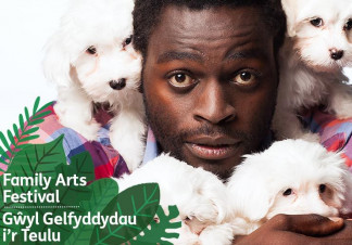 Two puppies sit on a man's shoulders while he cuddles two others. He is staring ahead with a blank expression