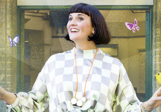 A woman looks happily into the distance. Two illustrated birds sit on her hands, and two illustrated butterflies hover either side of her