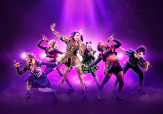 The cast of Six pose with microphones in front of a purple background
