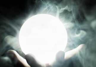 A hand holds a sphere glowing with white light